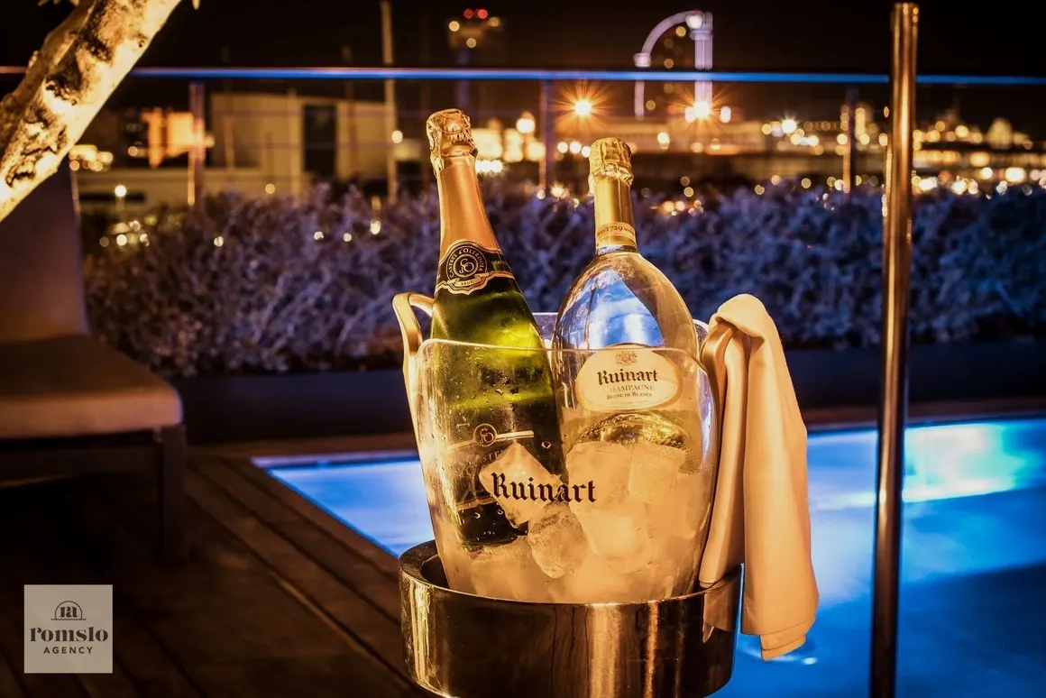 Chilled Ruinart champagne bottles at an elegant evening event by the poolside