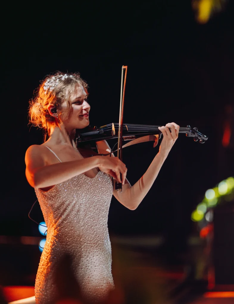 Live music by a girl in elegant couture playing the violin at a wedding Services.