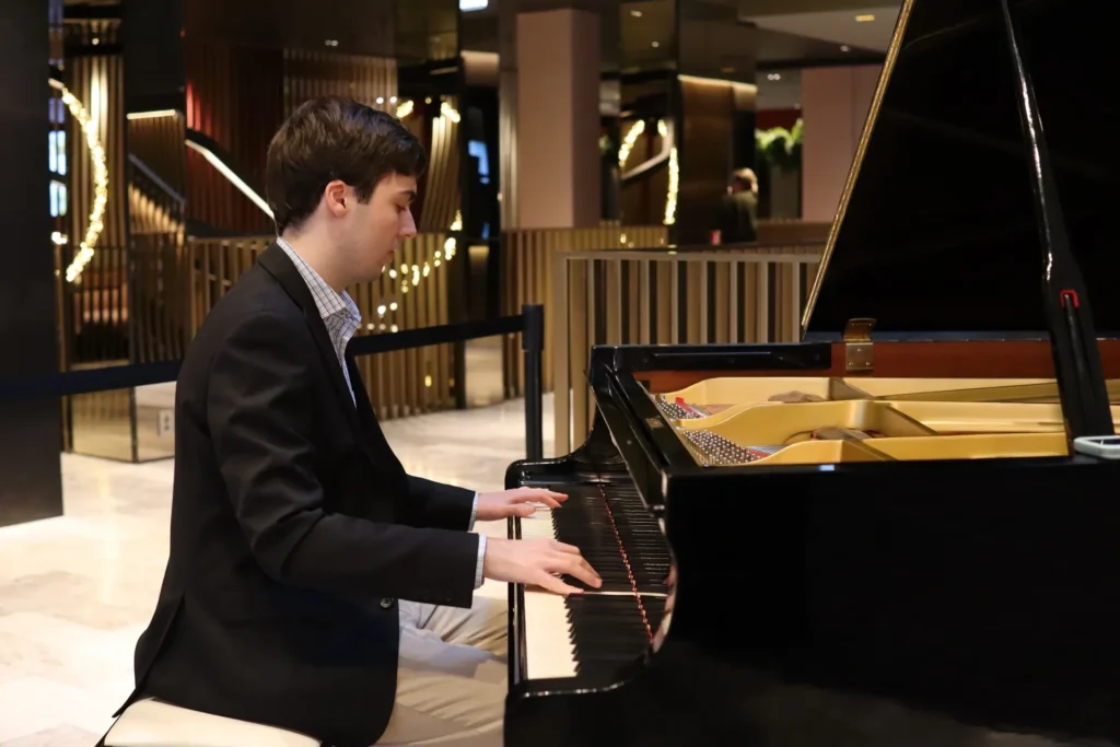 Pianist performing at a grand piano during an elegant event