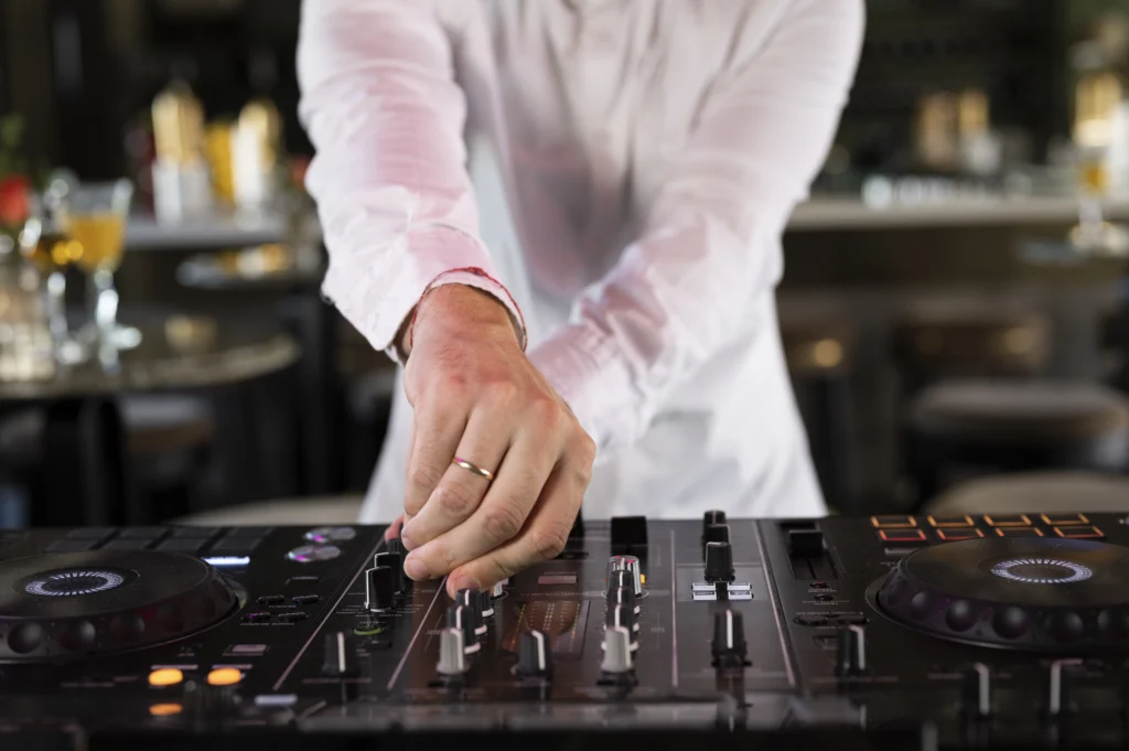 A male DJ in charge of music entertainment at a lively party.