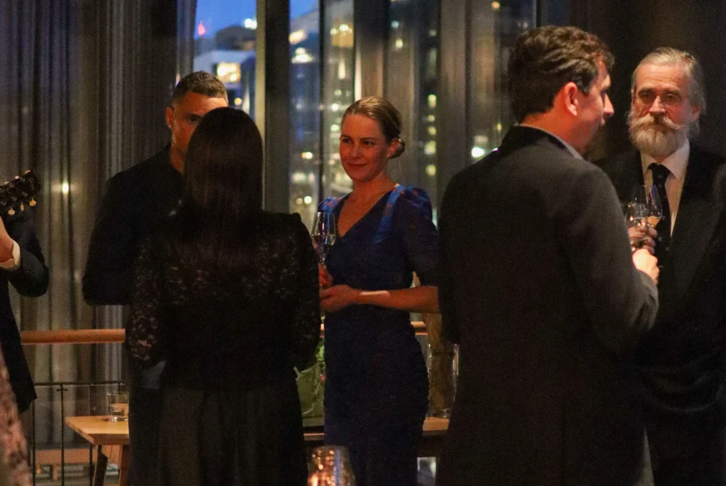 People engaging in conversation at a sophisticated corporate event.