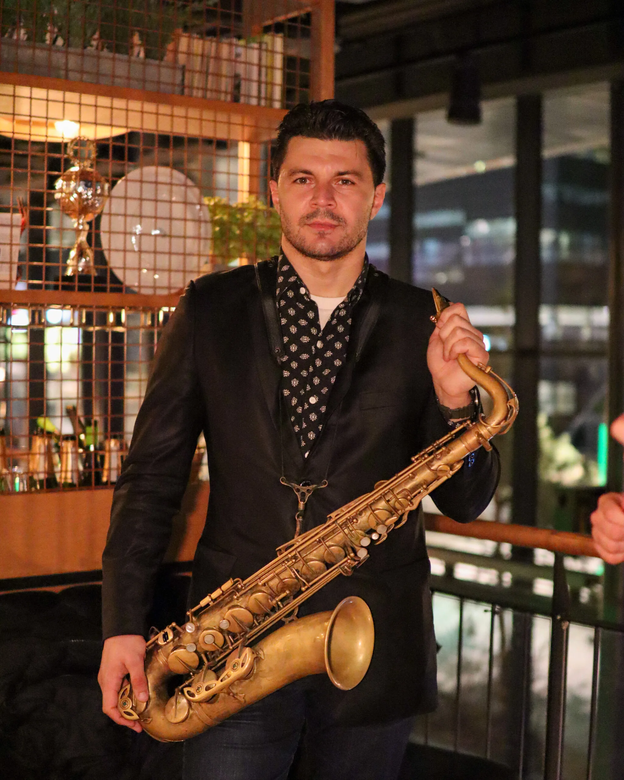 Johan, saxophonist from Romslo Entertainment, holding a saxophone at an elegant indoor private event in Norway.